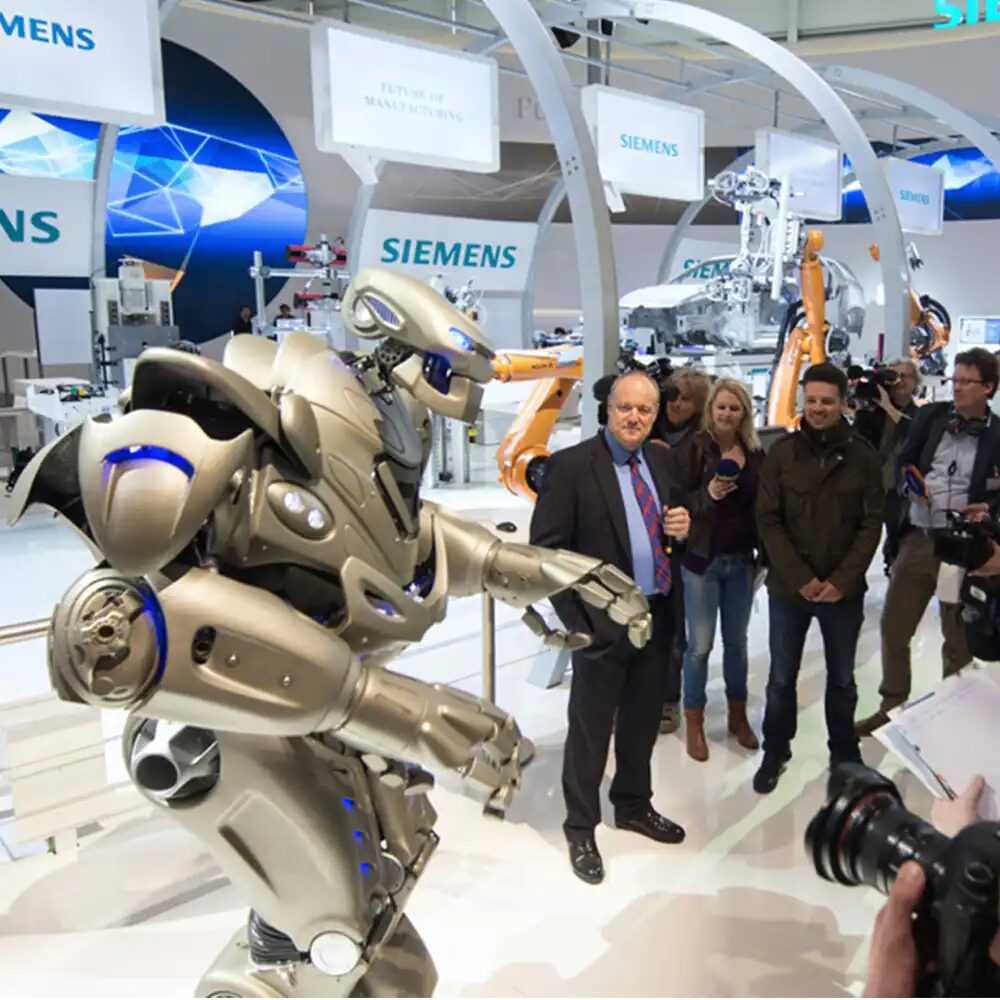 Titan the Robot in front of a car assembly line set up as part of the Siemens trade show stand.